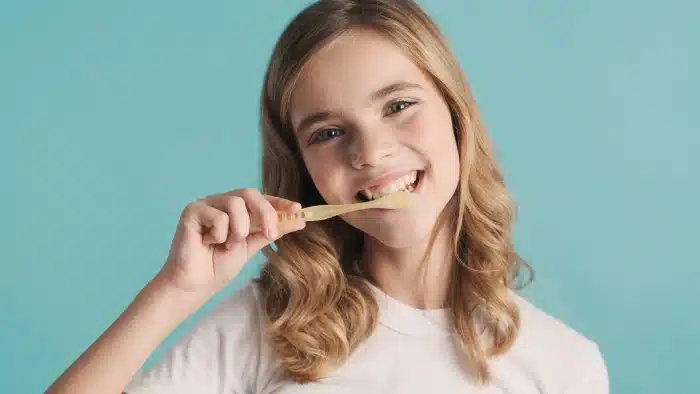 young female brushing her teeth ahead of her appointment at Lytle Family Dentistry 78052